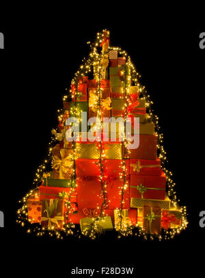Stack of many christmas presents illuminated like a christmas tree Stock Photo