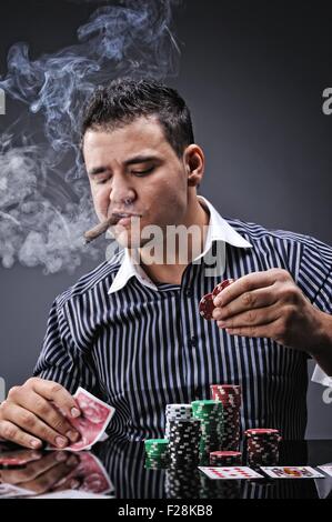 Portrait of a young gangster smoking and playing poker Stock Photo