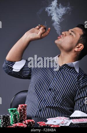 Portrait of a young gangster smoking and playing poker Stock Photo