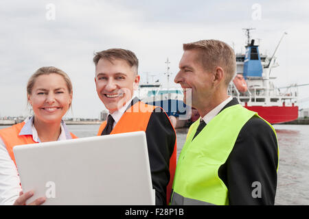 Portrait of business people working on laptop at harbour, Hamburg, Germany Stock Photo