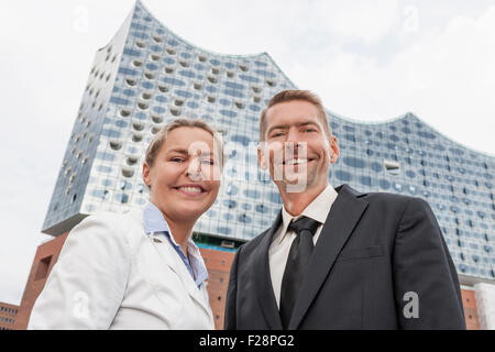 Portrait of business people standing at port and smiling, Hamburg, Germany Stock Photo