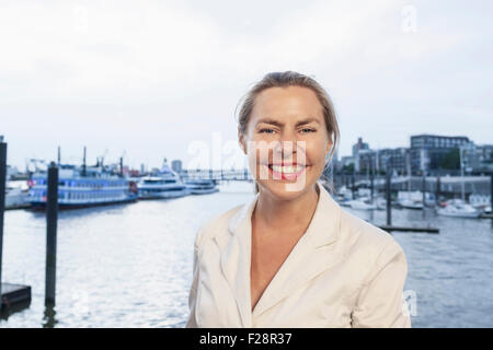 Portrait of a businesswoman smiling at harbour, Hamburg, Germany Stock Photo