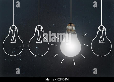 Light bulb standing out amongst sketched lamps on a chalkboard Stock Photo