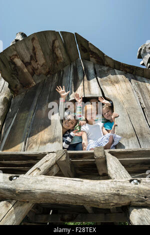 Girls playing on tree house in playground, Munich, Bavaria, Germany Stock Photo