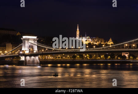 A beautiful night-time view of the Chain Bridge spanning the River Danube with the Fisherman’s Bastion and St. Matthias Church i