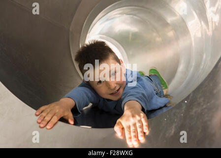 Boy sliding in a tunnel slide, Munich, Bavaria, Germany Stock Photo