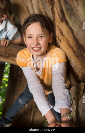 Girl climbing on tree house in a playground, Munich, Bavaria, Germany