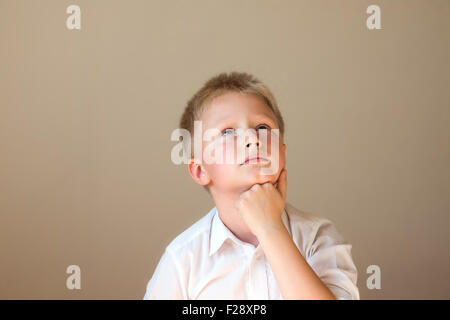 Child (boy) thinking over grey background Stock Photo