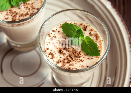 Chocolate Panna Cotta dessert with mint in portion glasses Stock Photo