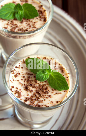 Chocolate Panna Cotta dessert with mint in portion glasses Stock Photo