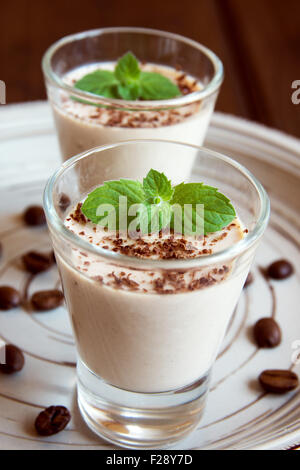 Coffee Panna Cotta dessert with coffee beans and mint in portion glasses Stock Photo