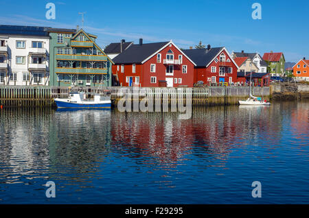 Red waterside fishing houses, Rorbu, on wooden stilts, with reflections Stock Photo
