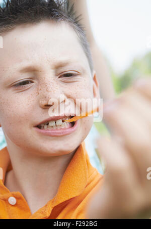 Boy pulling bubble gum out of his mouth, Bavaria, Germany Stock Photo