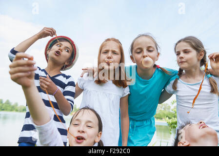 Group of friends playing with bubble gums, Bavaria, Germany Stock Photo