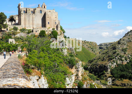 Troglodyte dwellings in a cliff wall and side view of Convent of Saint Agostino from Sasso Barisano, Matera. Stock Photo