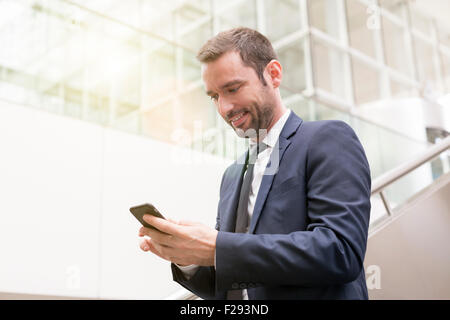 Businessman sending a SMS Stock Photo