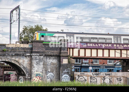 A London Midland train crossing the graffitied railway arches at Selly Oak, Birmingham, England, UK Stock Photo