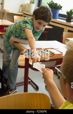 school students passing notes during exam in classroom, Munich, Bavaria, Germany Stock Photo