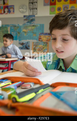 schoolboy reading a message in classroom, Munich, Bavaria, Germany Stock Photo