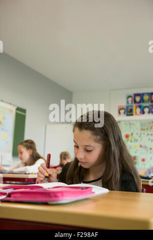 schoolgirls writing in notebooks, Munich, Bavaria, Germany Stock Photo