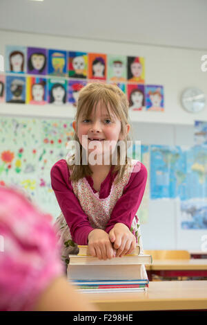 Portrait of a schoolgirl leaning on books, Munich, Bavaria, Germany Stock Photo