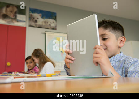 Schoolboy using a digital tablet in classroom, Munich, Bavaria, Germany Stock Photo