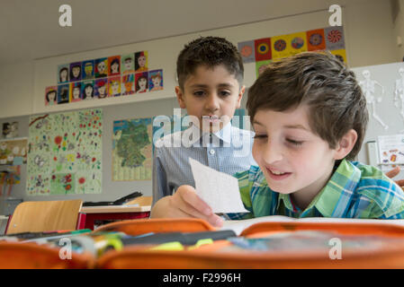 schoolboys reading a message in classroom, Munich, Bavaria, Germany Stock Photo