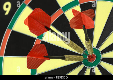 Three Darts in the Bulls Eye on Dart Board. Stock Photo