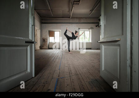 Mid adult woman practicing natarajasana pose in yoga studio, Munich, Bavaria, Germany Stock Photo