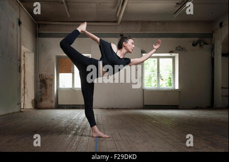 Mid adult woman practicing natarajasana pose in yoga studio, Munich, Bavaria, Germany Stock Photo
