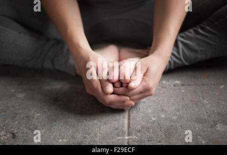 Low section view of a woman practicing cobbler pose in yoga studio, Munich, Bavaria, Germany Stock Photo