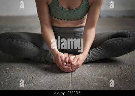 Woman practicing cobbler pose in yoga studio, Munich, Bavaria, Germany Stock Photo