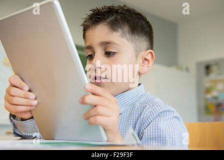 Schoolboy using a digital tablet in classroom, Munich, Bavaria, Germany Stock Photo