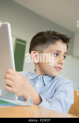 Schoolboy using a digital tablet in classroom, Munich, Bavaria, Germany Stock Photo
