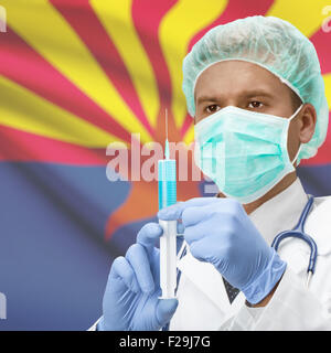 Doctor with syringe in hands and USA states flags on background - Arizona Stock Photo