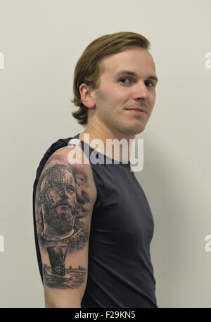 Garden City, New York, USA. 13th Sep, 2015. KRISTJAN VALDIMARSSON, from Akureyri, Iceland, displays the tattoo just completed by his brother Gunnar Valdimarsson, at the United Ink Flight 915 Tattoo convention at the Cradle of Aviation Museum in Long Island. The shirt sleeve is taped up away from tattoo, which has a traditional Nordic theme, with a bearded Viking man's head and Viking ship. © Ann Parry/ZUMA Wire/Alamy Live News Stock Photo