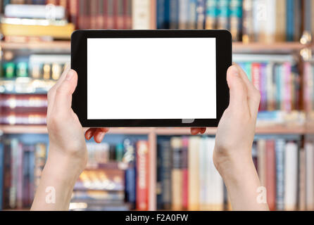 hands holding tablet pc with cut out screen in front of books library Stock Photo