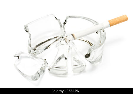 Smoking  cigarette in broken glass ashtray Stock Photo