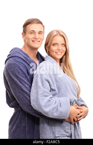 Young man in a bathrobe hugging his girlfriend and posing together isolated on white background Stock Photo
