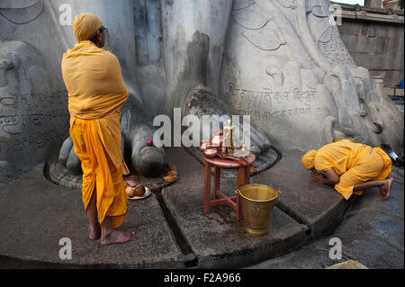 Two jaïn pilgrims are worshipping Gomateshwara, one of the main jaïn spiritual leader ( India) Stock Photo