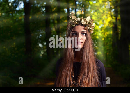 The young beautiful woman in dark forest Stock Photo