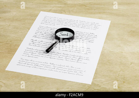 Magnifying glass enlarging the word Search on a page with printed text, laying on a desk Stock Photo