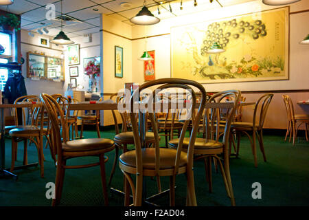 The interior of a Chinese Restaurant showing tables, chairs and wall hangings Stock Photo