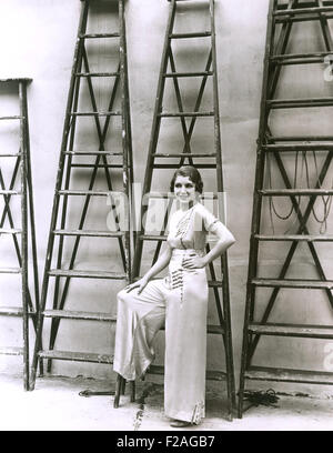 Young woman posing in front of ladders (OLVI008 OU199 F) Stock Photo