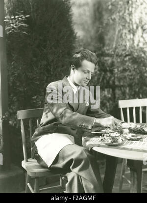 Young man having breakfast at outdoor table (OLVI008 OU102 F) Stock Photo