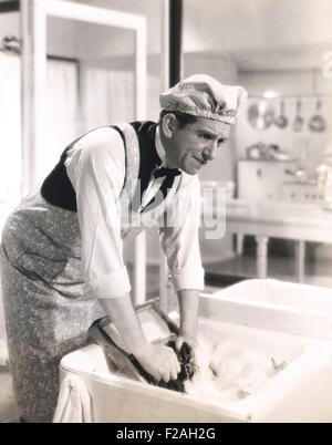 Man washing clothes in the kitchen sink (OLVI008 OU054 F) Stock Photo