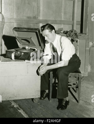 Man listening to portable gramophone (OLVI007 OU935 F) Stock Photo