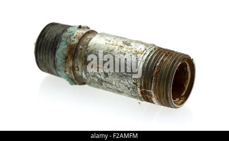 An old and leaking short pipe nipple with remains of pipe thread compound on a white background. Stock Photo