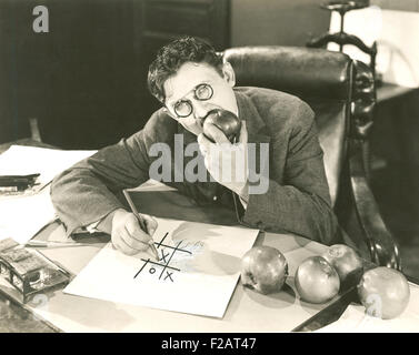 Eating apples during a game of tic tac toe (OLVI007 OU551 F) Stock Photo