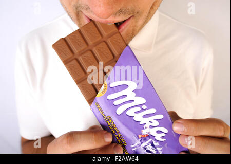 eating chocolate confection Milka-comiendo confección de chocolate Milka Stock Photo